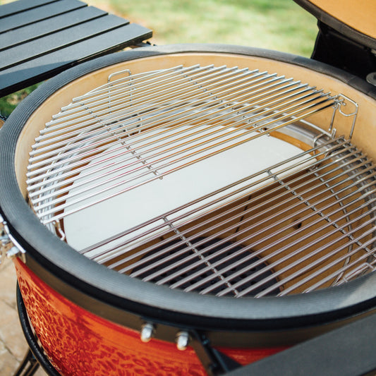 The inside of a new Kamado Joe grill with 2-tier Divide & Conquer racks and one half-moon heat deflector installed