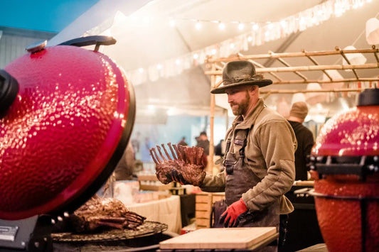 Chef Eric Gephart cooking ribs on Kamado Joe grills under a tent strung with lights