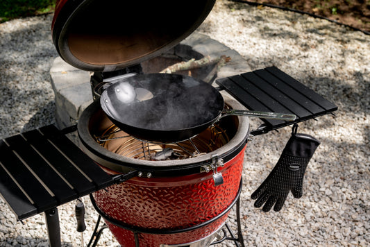 Karbon Steel wok seated on the accessory rack inside a Kamado Joe grill