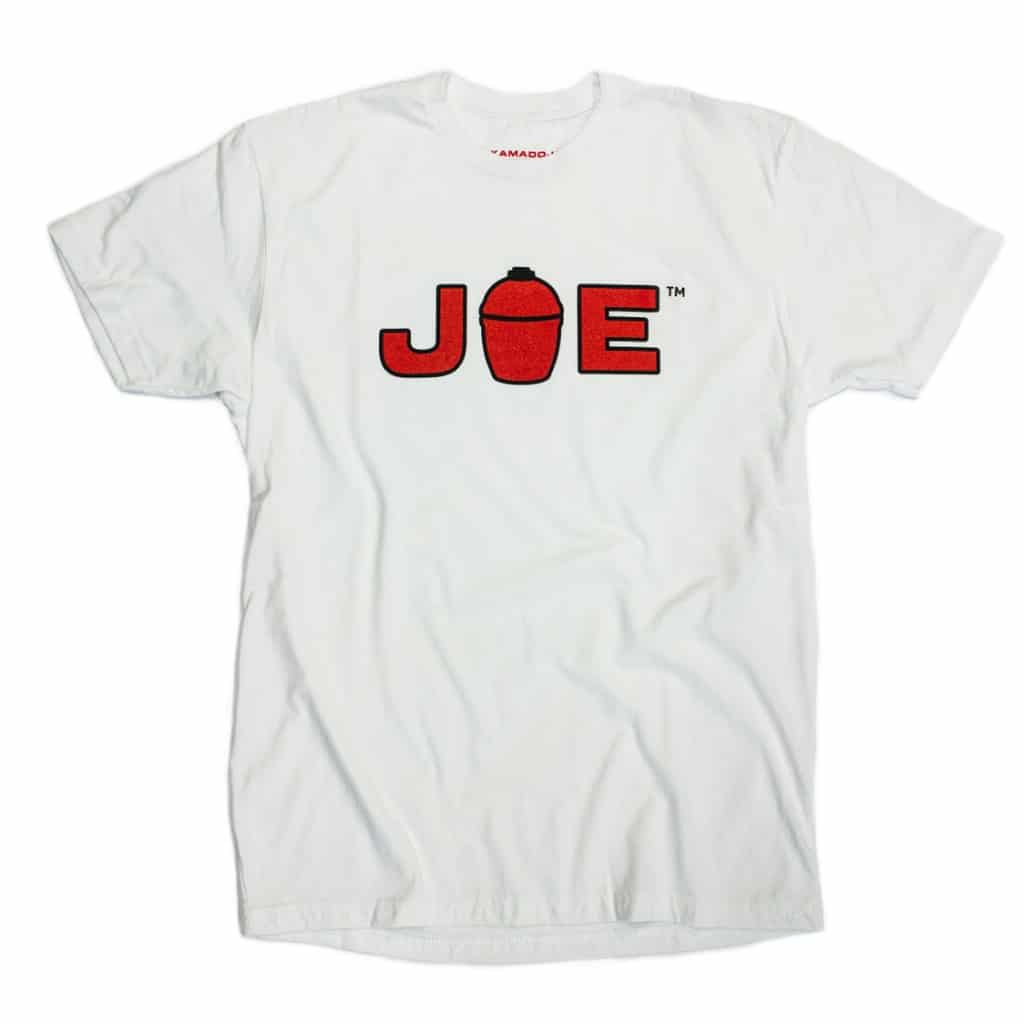 White t-shirt with "JOE" on the front in red letters outlined with black. The "O" has been replaced with a drawing of a Kamado Joe Grill.