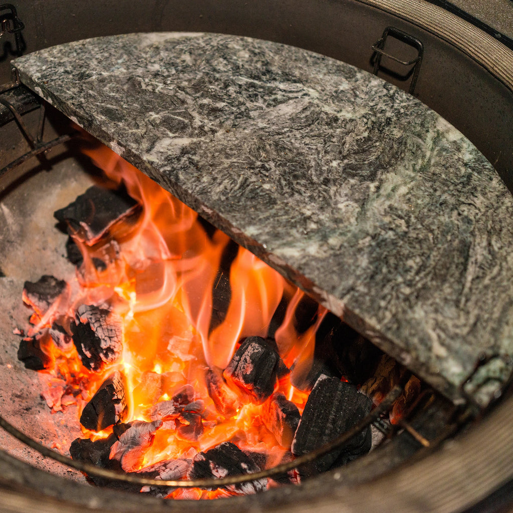 Coals flame below a half-moon soapstone installed in a Divide & Conquer  rack