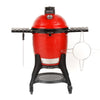 A red Classic Joe III grill with black side shelves, Kontrol Tower top vent, and heavy-duty cart with wheels. A temperature gauge is built into the grill dome. A sliding steel access door is built into the bottom of the grill base. Various accessories hang from the side shelves
