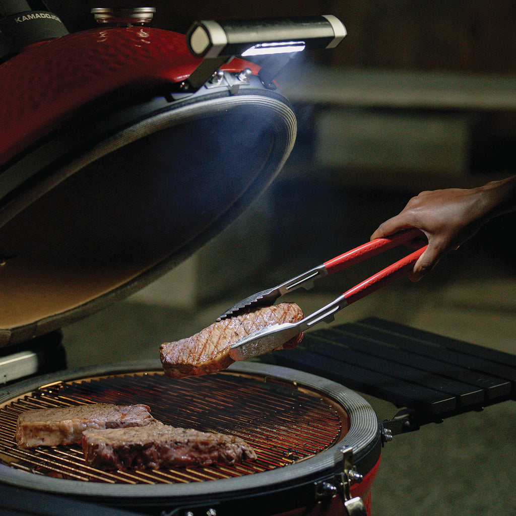 The LED Handle in use. The handle is mounted on the grill and the grill is open to show how the light shines onto the cooking surface once the lid is lifted.
