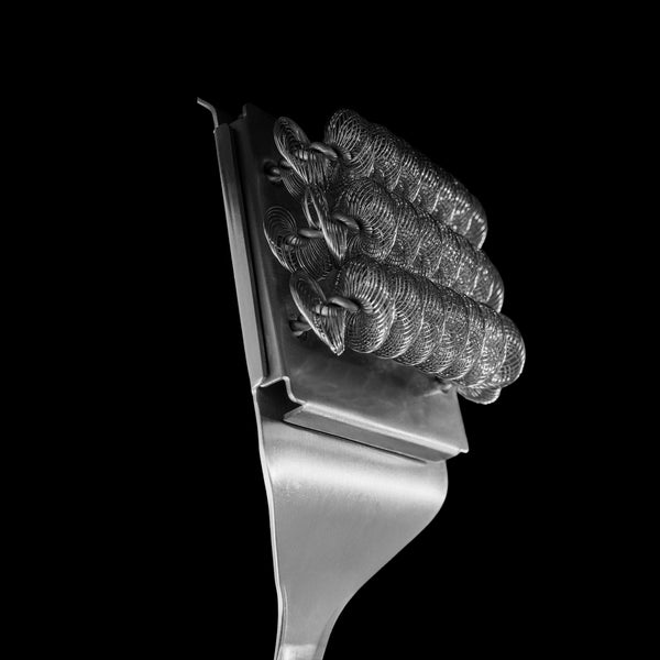 Closeup of the bristle side of the brush against a black background. The bristles are in 3 coils that run across the brush.