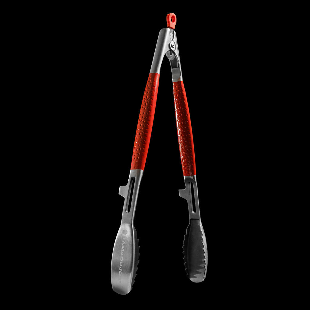 Open tongs against a black background. Tongs have dimpled red handles, grooved teeth, and resting notches to keep the tong head elevated when set down.
