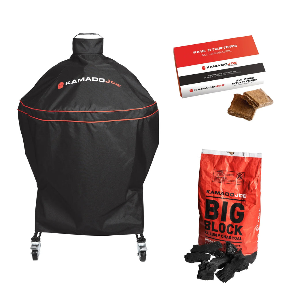 Kamado Joe black grill cover with red trim and logo, shown with a box of fire starters, two fire starters, and a bag of Kamado Joe Big Block charcoal on a white background.