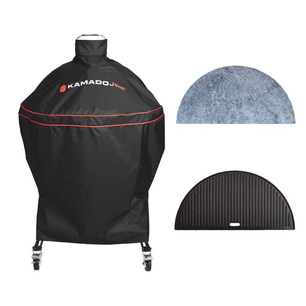 Black Kamado Joe grill cover with red piping and logo, shown with two included accessories: a half-moon soapstone and a half-moon cast iron reversible griddle, on a white background.