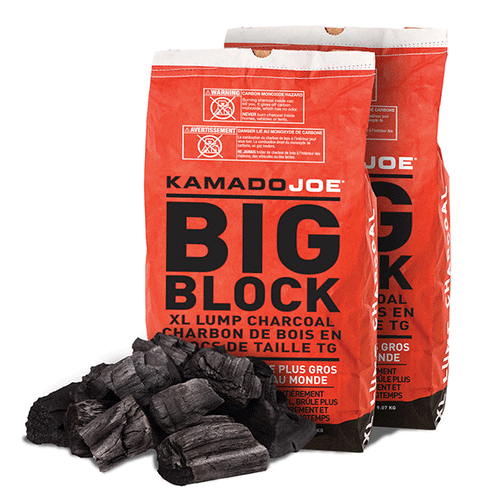 2 bags of Kamado Joe Big Block XL Lump Charcoal standing behind a small pile of charcoal lumps