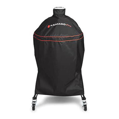 Black Kamado Joe grill cover with red accent piping and red and white brand logo, shown on a clean white background. Cover includes fitted sleeve for top vent and also covers the cart.