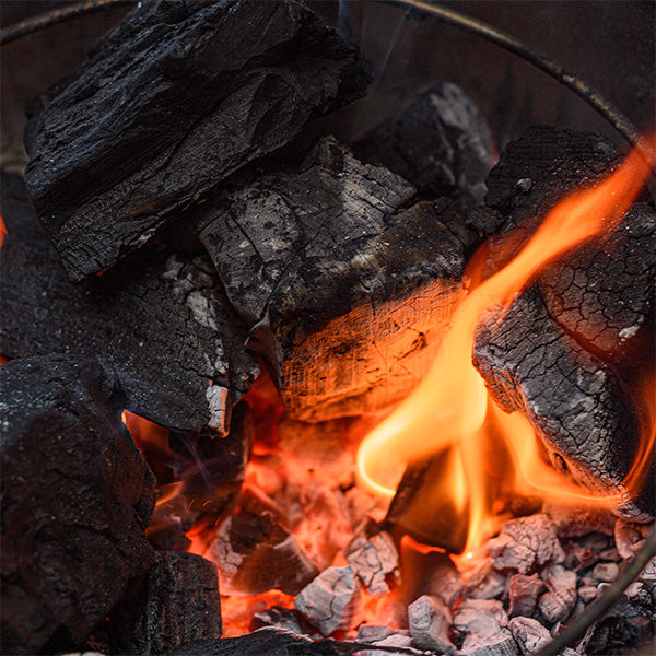 A burning Kamado Joe grill fire starter cube lights lump charcoal