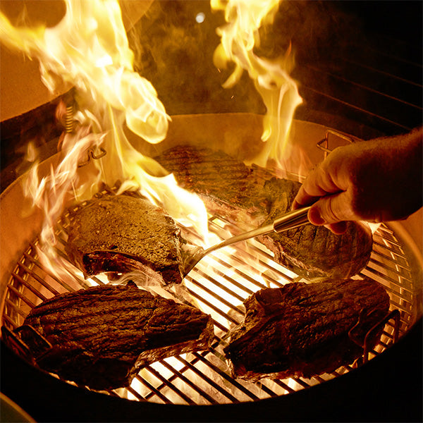 Cooking steaks on a flaming Kamado Joe grill