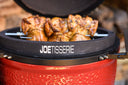 The JoeTisserie installed on the grill showing how the support sits firmly on the grill body